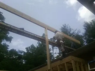 Carpenter setting a ridge beam over a new addition frame — Ice Dam Removal by Roofing Brothers in Port Townsend