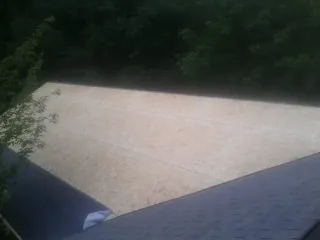 New OSB roof sheathing installed beside an existing shingle roof in Port Townsend