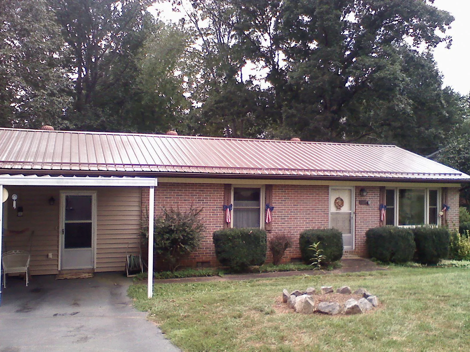 Bronze metal roof and carport on a brick ranch home — Roof Repair work by our crew in Port Townsend
